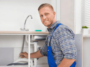 plumber is smiling and holding faucet pipes